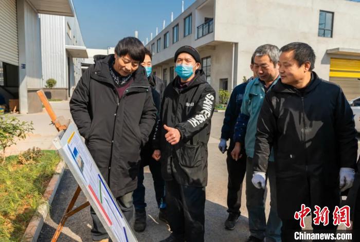 員工圍在展板前了解就地過年相關(guān)政策。婺城宣傳部供圖