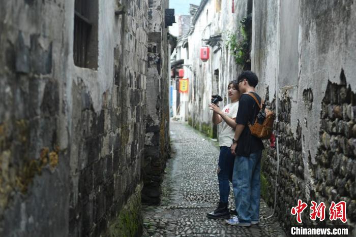 臺(tái)灣青年在龍門(mén)古鎮(zhèn)的巷道中拍攝。　王剛 攝