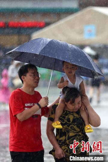 市民冒雨前行?！°蟛?攝