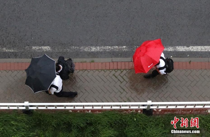 北京遇今年汛期最強(qiáng)降雨 市民冒雨出行