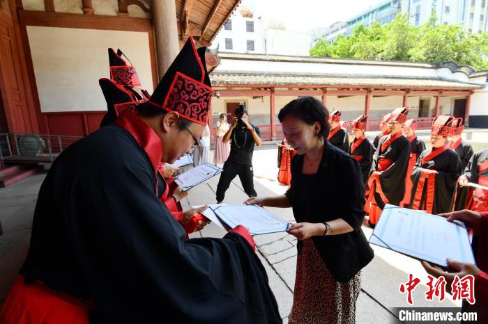 圖為嘉賓為臺(tái)灣學(xué)子頒發(fā)“漢服漢禮典儀官”培訓(xùn)證書(shū)。　呂明 攝