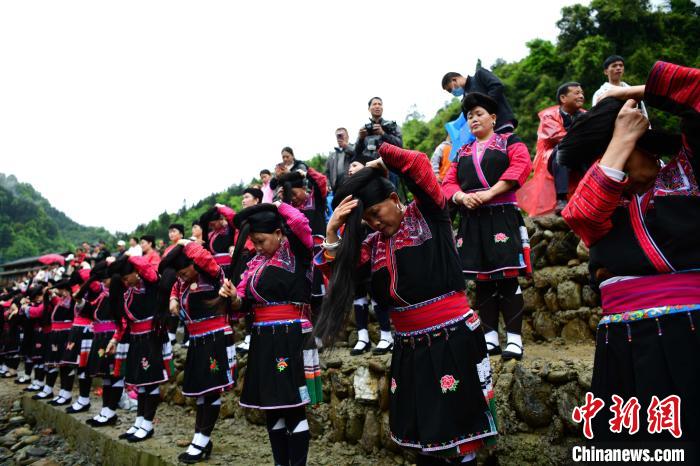 4月14日，在廣西桂林龍勝各族自治縣龍脊鎮(zhèn)黃洛瑤寨，瑤族同胞在河邊梳理長發(fā)?！?潘志祥？　攝