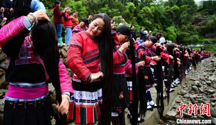 4月14日，在廣西桂林龍勝各族自治縣龍脊鎮(zhèn)黃洛瑤寨，瑤族同胞在河邊梳理長發(fā)。　 潘志祥？　攝