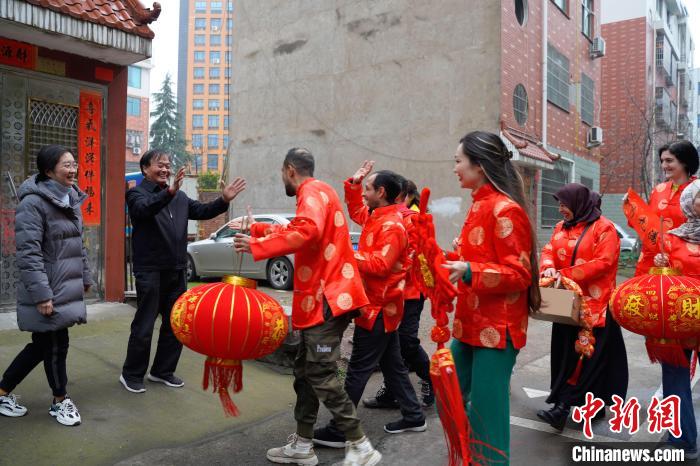 長期居住在雞鳴山社區(qū)的外籍人士到達(dá)該社區(qū)居民劉樟根家樓下，送上節(jié)日的祝福。　董易鑫 攝