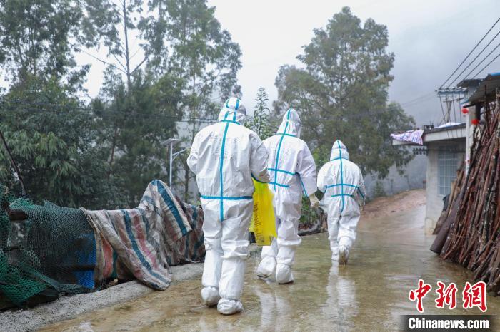 圖為在德?？h隆桑鎮(zhèn)果甫村，身著厚重防護(hù)服的歐秋潔和同伴步履蹣跚地行走。