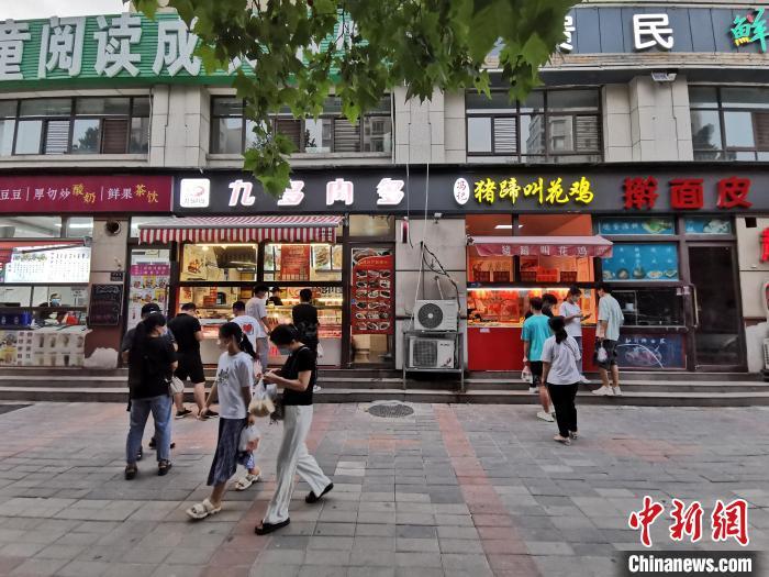 資料圖：市民在街邊小店購(gòu)買(mǎi)小吃。 韓章云 攝