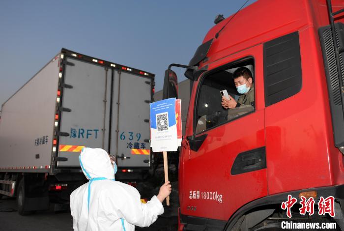 工作人員舉牌讓貨車司機(jī)掃碼?！⊥鮿?攝