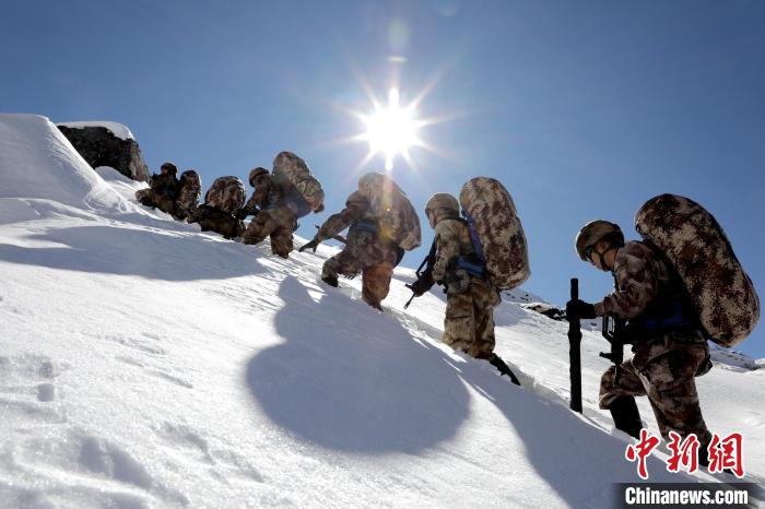 圖為巡邏官兵翻越雪山?！●R軍 攝