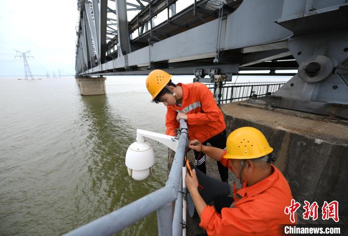 6月24日，南鐵九江橋工段的橋梁工正在九景衢鐵路鄱陽湖大橋上對(duì)監(jiān)控?cái)z像頭進(jìn)行檢修?！『鷩?攝