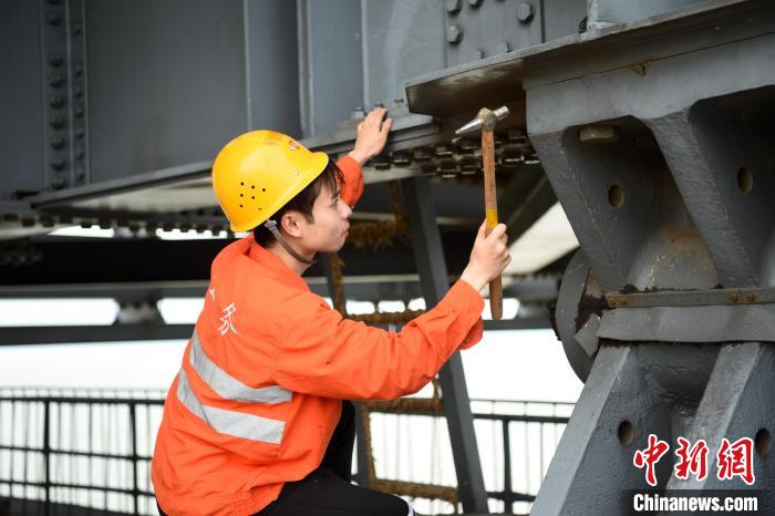 6月24日，南鐵九江橋工段的橋梁工正在九景衢鐵路鄱陽湖大橋上對(duì)高強(qiáng)度螺栓進(jìn)行檢查更換?！?黃旸 攝