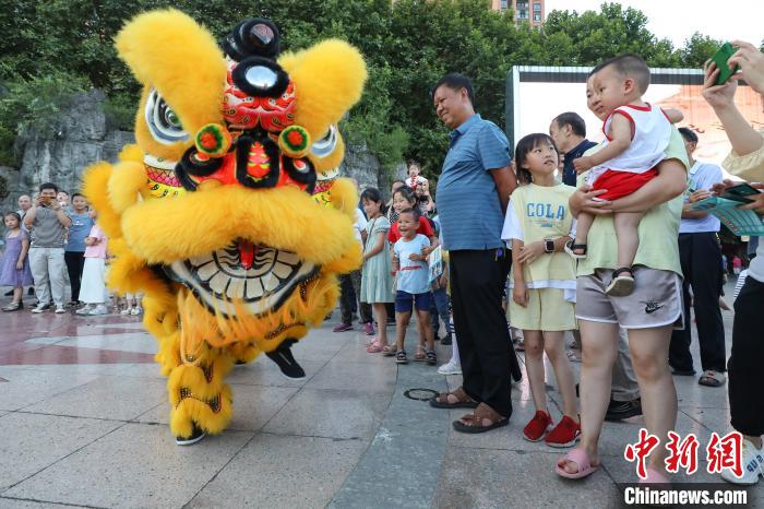 賴翊凡(獅頭)與李洪江配合在縣城詩(shī)鄉(xiāng)廣場(chǎng)練習(xí)舞獅吸引市民觀看?！■暮陚?攝