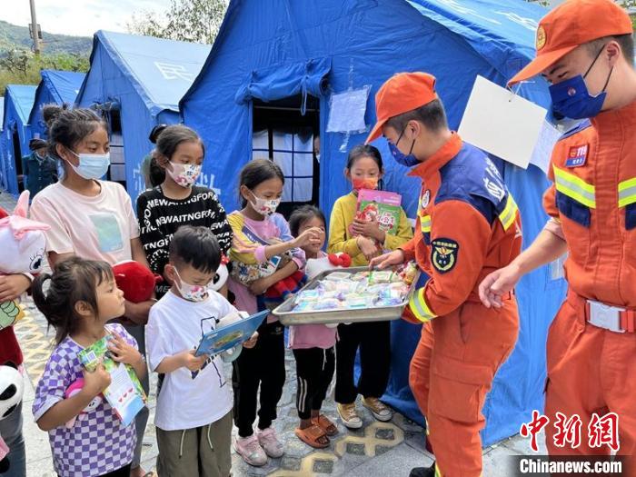 臨時(shí)安置點(diǎn)消防員給村民和孩子送上中秋月餅?！埼?攝