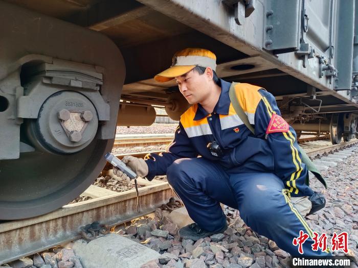 圖為張建亮在檢查車輛軸承溫度?！≈炜△?攝