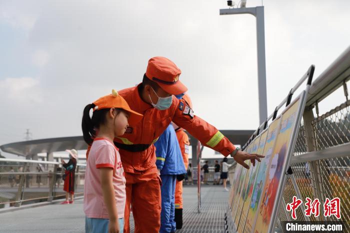 森林消防員正在防火宣傳展板前與小朋友進(jìn)行科普講解?！↑S山鴻 攝