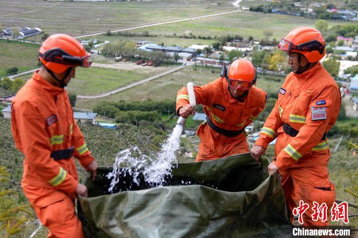 技能大練兵過(guò)程中，消防員在陡坡上向蓄水池注水?！±顕?guó)燾 攝