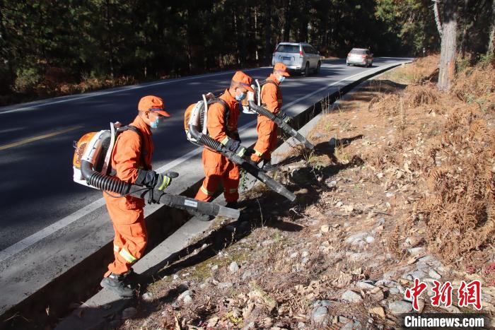 消防隊員利用風力滅火機收攏國道旁可燃物?！⊥鯘蓷?攝