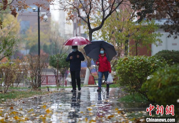 資料圖：市民雨中出行?！∮诰?攝