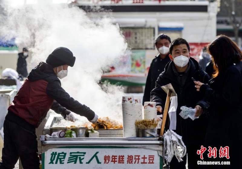 資料圖：外出購(gòu)物的市民購(gòu)買品嘗街頭小吃。 劉新 攝