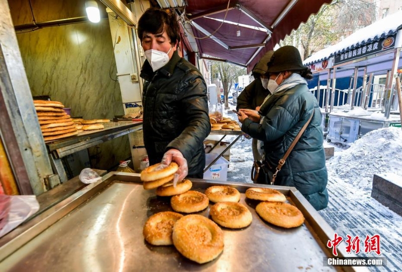 烏魯木齊市文化路，已開門營(yíng)業(yè)的馕店吸引過往市民前來購(gòu)買。 劉新 攝