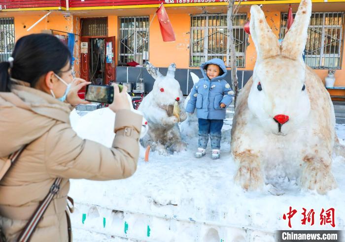 不少行人拍照上傳朋友圈，這些雪雕兔子經(jīng)社交平臺傳播一時成了當?shù)亍熬W(wǎng)紅”。　楊俊欽 攝