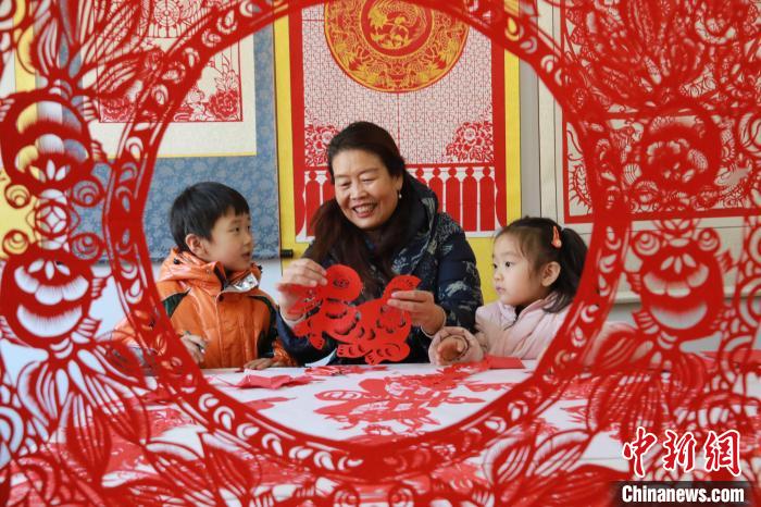 非遺傳承人田桂芹在帶領(lǐng)孩子們進(jìn)行迎新年剪紙創(chuàng)作?！±詈?攝