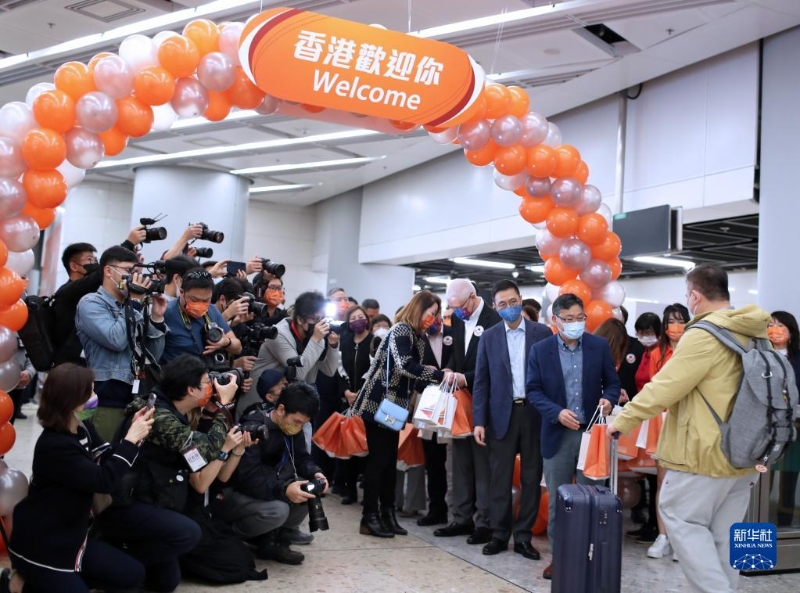 1月15日，在香港的西九龍站，工作人員迎接恢復通車后內地駛往香港首趟列車的旅客并贈送小禮物。新華社記者 李鋼 攝