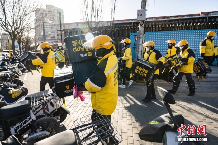 圖為外賣送餐員在北京市朝陽區(qū)的街頭開完早會后投入工作。 <a target='_blank' href='/'>中新社</a>記者 侯宇 攝