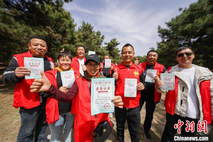 4月15日，完成徒步過(guò)程的愛(ài)好者展示獲得的榮譽(yù)證書(shū)?！≮w亮 攝