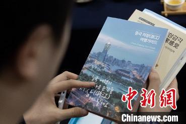 參展觀眾閱讀浙江文旅手冊(cè)?！《≌裾?攝