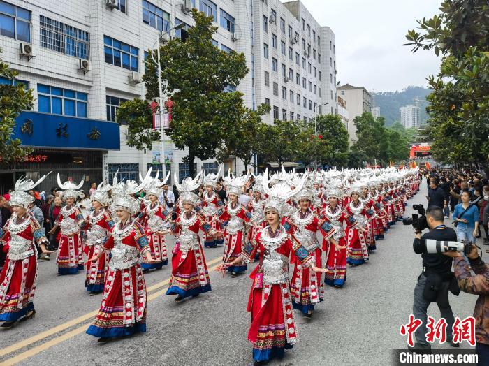 上百名美麗的姑娘著節(jié)日盛裝與蘆笙隊(duì)伍進(jìn)行巡游?！「毒窜?攝