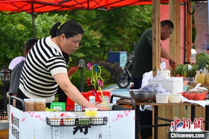 上金貝村村民擺攤售賣畬族美食?！∮嗌强?攝