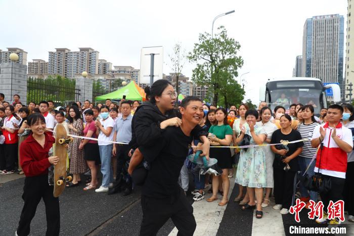 圖為蔣張子怡的父親背著她往外走，母親拿著女兒的滑板跟在后面?！⒄祭?攝