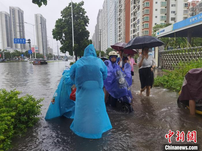 6月8日，強(qiáng)降雨過后，北海市民涉水出行。　翟李強(qiáng) 攝