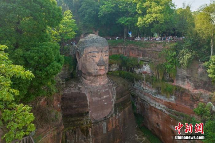 遠(yuǎn)眺樂(lè)山大佛，旁邊佛頭觀景平臺(tái)擠滿了游客。劉忠俊 攝