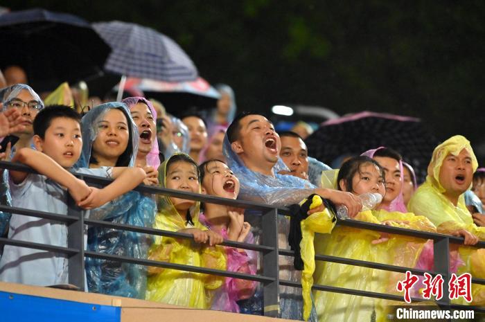 球迷冒雨觀賽，大聲吶喊助威。　俞靖 攝