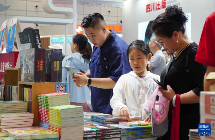 7月27日，在第31屆全國(guó)圖書(shū)交易博覽會(huì)上，讀者在閱覽新書(shū)。新華社記者 徐速繪 攝