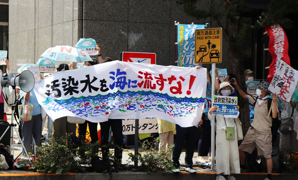 8月24日，日本民眾手持“不許將污染水排入大?！钡葮苏Z在東京電力公司總部前集會，抗議日本政府和東電公司無視民意啟動核污染水排海。（圖源：新華網(wǎng)）